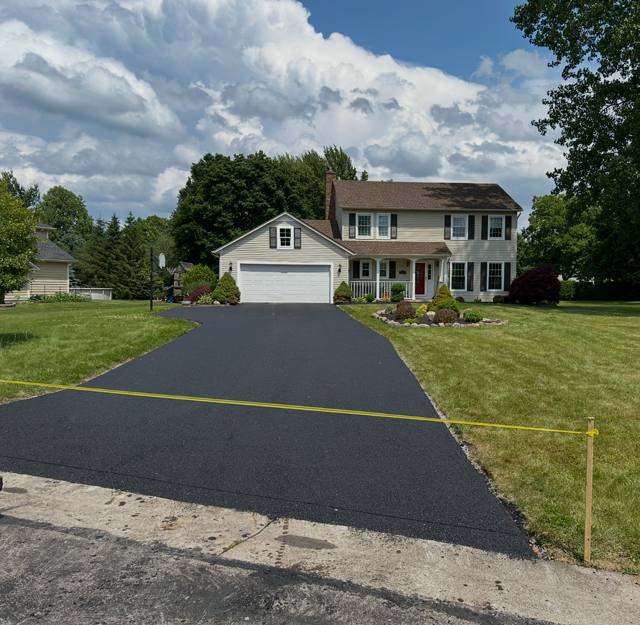 Freshly paved curved driveway in front of a colonial home