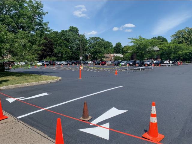 Freshly sealed parking lot with new white arrows and cones