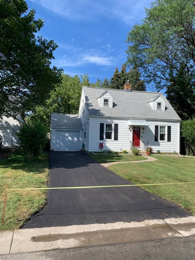 New driveway at a white Cape Cod home with a red door