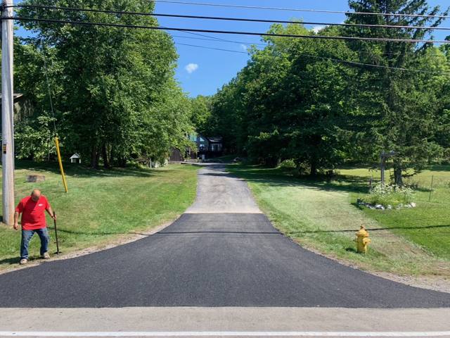 Freshly paved driveway apron at a rural property