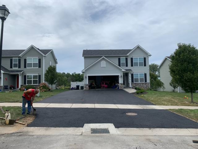 Crew finishing the edge of a new driveway apron