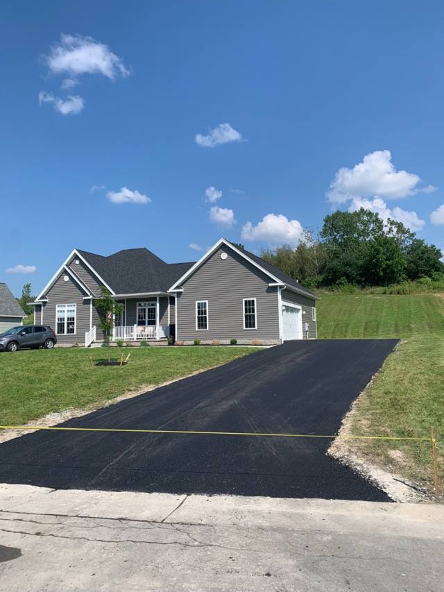 New driveway at a newly built gray ranch home