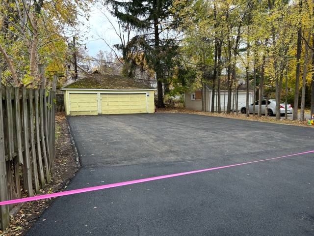 Newly paved rear parking area in front of garages