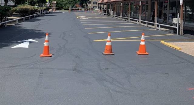 Newly sealed plaza parking lot with cones