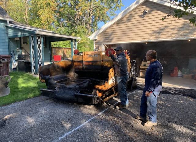 Paving crew with a paver at a residential driveway