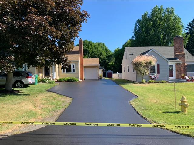 Freshly sealcoated driveway between two homes